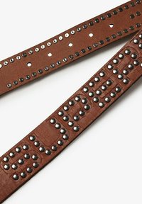 Bruine leren band met structuur, voorzien van zilveren en zwarte studs, met een reliëfpatroon en decoratieve metalen accenten langs de randen.
