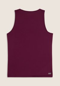 Camiseta sin mangas de color burdeos hecha de tela suave. Presenta un escote redondo y un dobladillo cosido con una pequeña etiqueta de logo en la parte inferior izquierda.