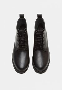 Stivaletti neri in pelle con finitura liscia, dotati di una chiusura con lacci, punta rotonda e un pratico tassello per facilitarne l'indossamento.