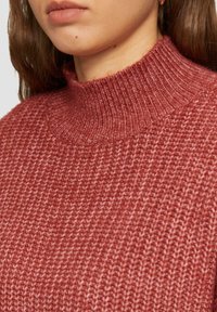 Różowy sweter z golfem, dziany, o fakturowanym wzorze, z prążkowanym dekoltem i miękkim, przytulnym materiałem.