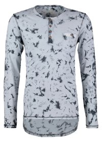 Chemise grise à manches longues avec un motif abstrait noir, encolure arrondie, patte de boutonnage à cinq boutons et petite poche poitrine.