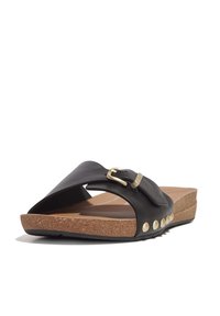 Zwarte leren slide sandalen met een brede band, gouden gesp, kurken voetbed en gouden accenten langs de zool. Getextureerde loopzool voor grip.