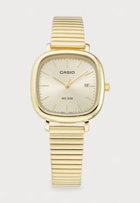 Montre Casio en ton or avec un cadran carré, bracelet texturé doré, affichage de la date à 3 heures et résistance à l'eau jusqu'à 50 mètres.