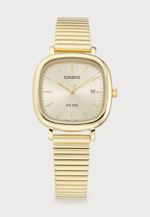Gold-tone Casio watch with a square face, golden textured strap, date display at 3 o'clock, and water resistance up to 50 meters.