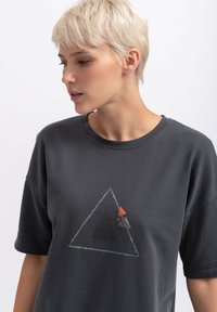 Grijze katoenen T-shirt met een driehoekig ontwerp met rode en zwarte accenten. Het ontwerp is gecentreerd op de borst en heeft een ontspannen pasvorm.