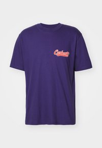 Purple cotton t-shirt with short sleeves, featuring a red embroidered "Carhartt" logo on the left chest area, smooth texture.