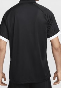 Svart sportskjorta med kort ärm och vitt kantband vid ärmsluten, tillverkad av lätt material. Har en vanlig passform och en klassisk krage.