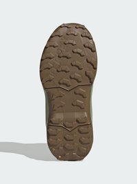 Hnědá pryžová podrážka boty s vícesměrnými trakčními výstupky, texturovaným povrchem a vyraženým označením u paty.