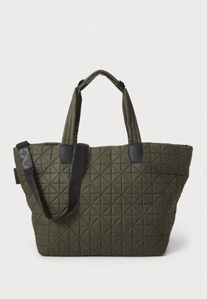 Quiltet oliven grønn tote-veske med trekantede mønstre, solide doble håndtak, svarte detaljer og et romslig interiør for organisering.