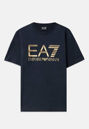 Marineblå bomull t-skjorte med et stort gulltrykt "EA7"-logo og "EMPORIO ARMANI"-tekst foran. Rund hals og korte ermer.