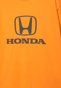 Orange bomulds t-shirt med et stort gråt Honda-logo centreret på forsiden. Stoffet ser glat ud med en almindelig pasform.