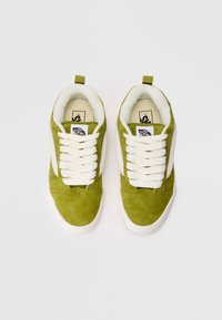Sneaker verde in suede con lacci bianchi, dotata di una collo imbottito e una striscia laterale bianca a contrasto. Vista dall'alto.