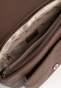Interno di una borsa in pelle marrone con una fodera liscia, due tasche con zip e una chiusura a scatto. Presenta un'etichetta con il logo all'interno.