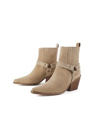 Tan suede ankle boots with a pointed toe and a stacked heel. Features a strap with flat studs and vertical ribbing on the shaft.