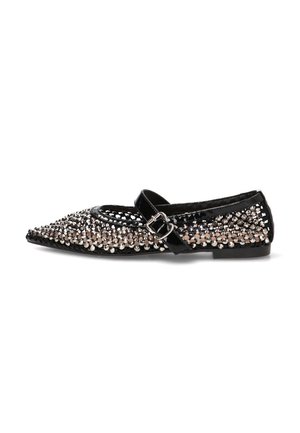 Zapato plano puntiagudo de charol negro con pulsera en el tobillo y tachuelas plateadas que cubren la superficie superior.