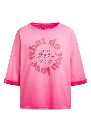 Bright pink short-sleeve shirt with circular text design reading "What do you love" and smaller text "SOCCX Start New New Chapter" on front.
