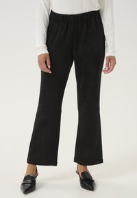 Pantalones acampanados negros hechos de una tela suave y elástica con una cinturilla ancha. Presentan detalles de costura en los muslos y una silueta elegante.