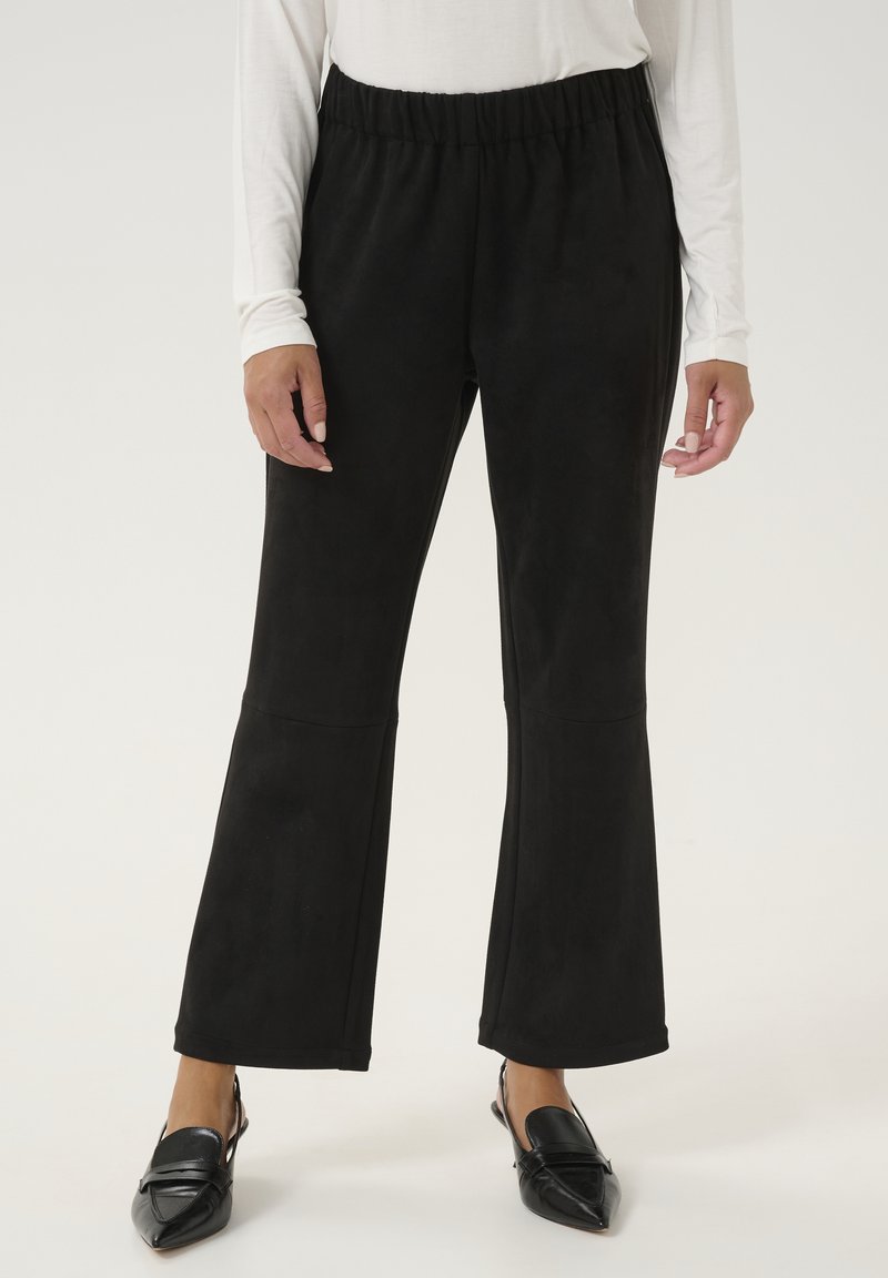 Pantalones acampanados negros hechos de una tela suave y elástica con una cinturilla ancha. Presentan detalles de costura en los muslos y una silueta elegante.