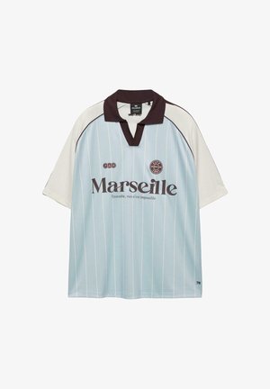 Lyseblå og hvid sports-T-shirt med korte ærmer og sort krave, teksten "Marseille", pins og sloganet "Ensemble, rien n'est impossible" på fronten.