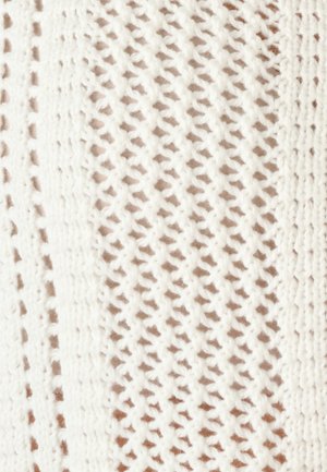 Tejido blanco de punto con patrones repetitivos de rombos calados y costillas que crean rayas verticales texturizadas.