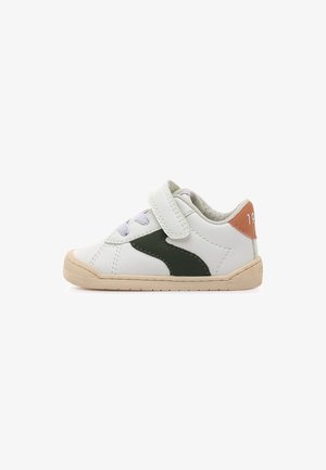 Baskets en cuir blanc avec accent vert, semelle beige et bride à velcro. Caractérisées par des coutures discrètes et un détail orange sur le talon.