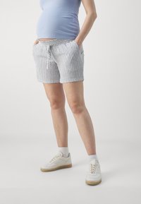 Shorts rayés en bleu et blanc, fabriqués en tissu léger, avec une taille à nouer, deux poches avant et une coupe décontractée.