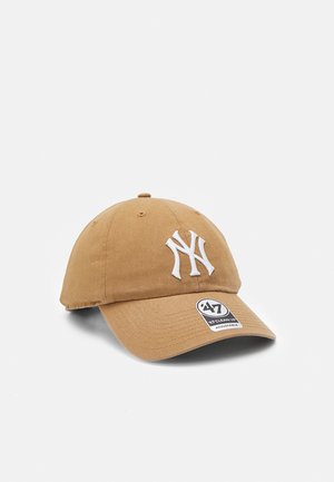 Brown cotton baseball cap with a white embroidered NY logo on the front and a circular tag on the visor. Adjustable closure at the back.