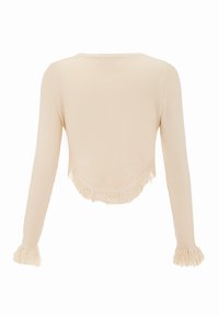 Beige geribbelde top met lange mouwen, met franjes aan de onderkant en op de manchet, met een afgeronde achterkant. Zachte textuur, slim-fit pasvorm.