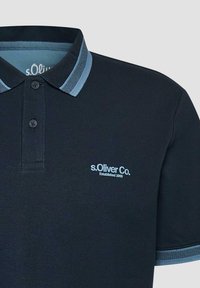 Polo bleu marine avec col et bordures de manches à rayures bleu clair, deux boutons, et logo "s.Oliver Co. Established 1969" sur la poitrine.