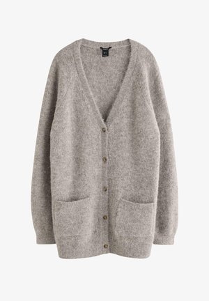 Grå ullkofta med V-ringning, knäppning framtill och två framfickor. Mjuk textur med en något lös passform och ribbade ärmslut.