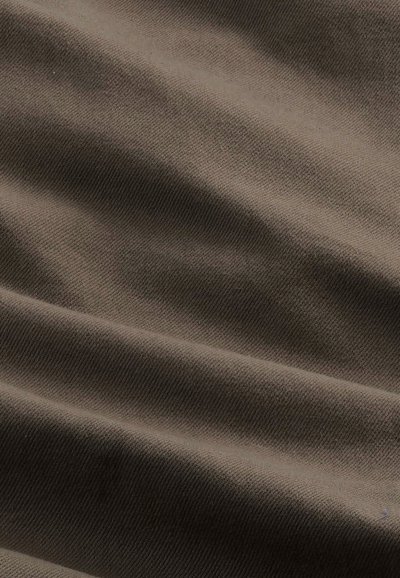 Zbliżenie na gładką, ciemnobrązową tkaninę z widoczną drobną diagonalną fakturą splotu oraz delikatnymi fałdami tworzącymi łagodne cienie.