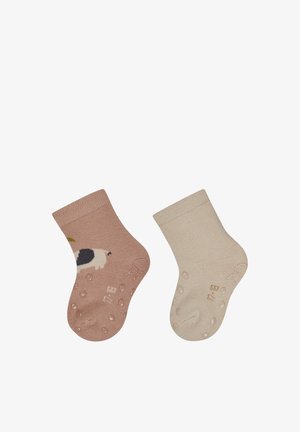 Two toddler socks with anti-slip grips; one beige with a dog design, the other plain cream-colored. Both have non-slip dots on soles.