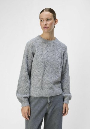 Grå strikket sweater med et struktureret mønster, rund halsudskæring og ballonærmer, parret med lyse denim jeans.