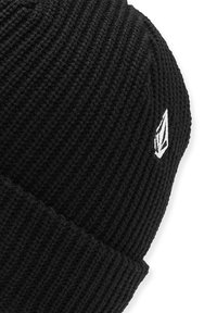 Bonnet en tricot noir avec une texture côtelée. Présente un petit logo blanc sur le côté. Tissu durable adapté aux temps froids.