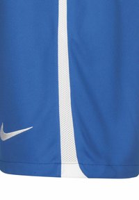 Nike Sportshorts aus blauem Stoff mit weißen Seitenstreifen, die entlang der Nähte eine Netzstruktur aufweisen und ein kleines weißes Logo haben.