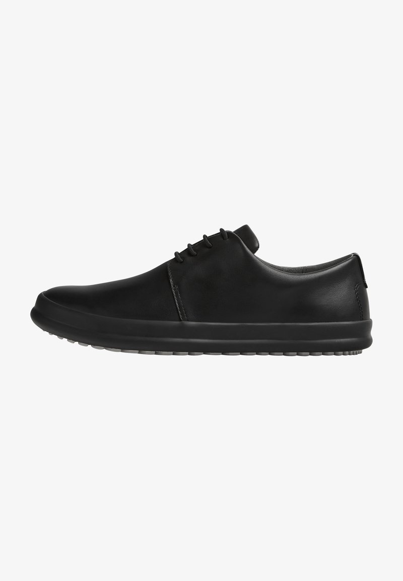 Scarpe nere in pelle con una superficie liscia, punta tonda, design minimalista, chiusura con lacci e suola in gomma flessibile.