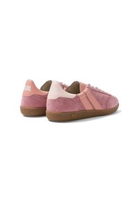 Paire de baskets basses en daim rose avec des rayures rose clair, semelles en caoutchouc marron et lacets blancs, vues de trois quarts arrière sur fond blanc.