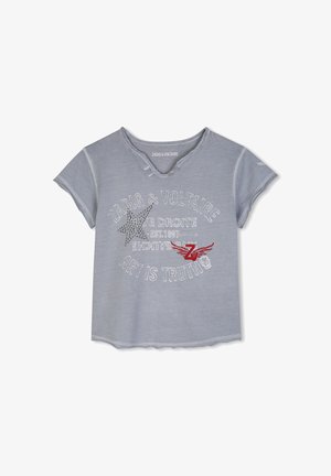 Jasnoniebieski T-shirt z krótkim rękawem, z postrzępionym dekoltem, zdobioną ćwiekami gwiazdą, czerwonym skrzydlatym logo "ZV" i nadrukiem białego tekstu w formie koła z przodu.