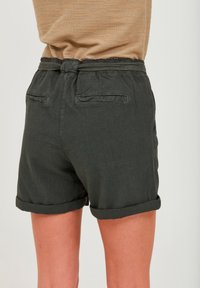 Pantaloni corti verde scuro realizzati in tessuto leggero, con orlo arrotolato, due tasche posteriori e una vita elasticizzata con dettaglio a corda.