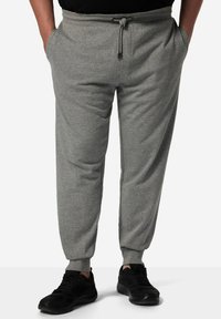 Grijze sweatpants van een zachte katoenmix, met een elastische tailleband met trekkoord, zijzakken en taps toelopende mouwen. Draag ze met zwarte sneakers.