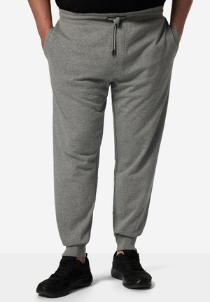 Grå sweatpants lavet af blødt bomuldsblanding, med elastisk talje og snor, sidelommer og snævre manchetter. Båret med sorte sneakers.