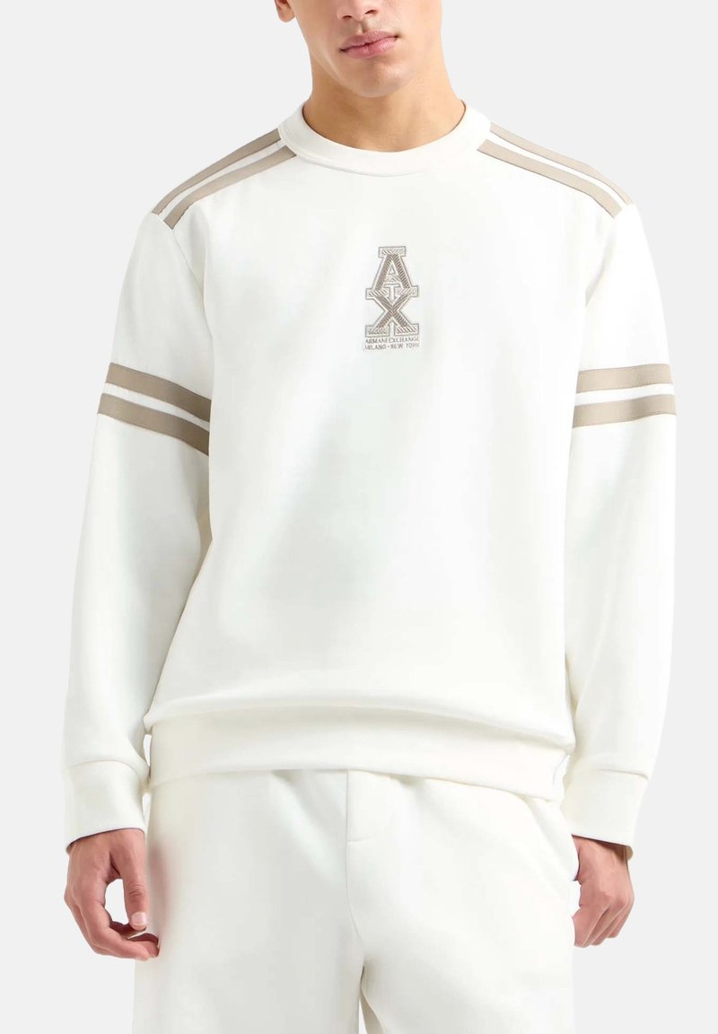 Weißer Sweatshirt mit Rundhalsausschnitt, hellbeige Streifen auf den Schultern und einem Logo auf der Brust. Weiche Textur, lockere Passform.