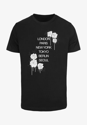 Black t-shirt featuring white floral graphics with roses and city names: London, Paris, New York, Tokyo, Berlin, Seoul. Simple, casual design.