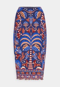 Jupe en tricot bleue avec un motif floral coloré et des palmiers, dotée d'un ourlet à franges et d'une silhouette ajustée.