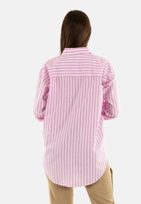 Camicia a maniche lunghe a righe verticali rosa e bianche, con colletto classico e orlo curvo. Materiale in cotone, vestibilità rilassata.