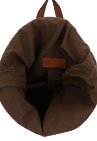 pruun kangaskott, millel on rullitud ülaosa ja nahkne aktsent. Interjöör on pehme tekstuuriga, sileda pruuni nahkpinnaga.