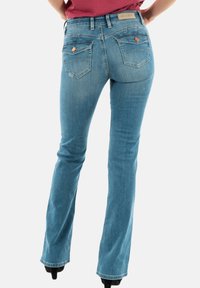 Svijetloplave traperice sa strukom koji se lijepo prsuje, proširenim nogavicama i dva stražnja džepa s ukrasnim šavovima i mjedenim detaljima.