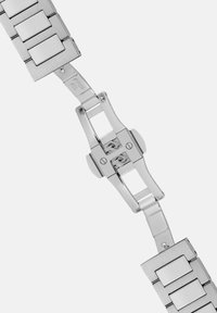 Metall armbandsur med länkar som har en borstad och polerad yta, rektangulära former och ett säkert viklås. Silverfärg hela vägen.