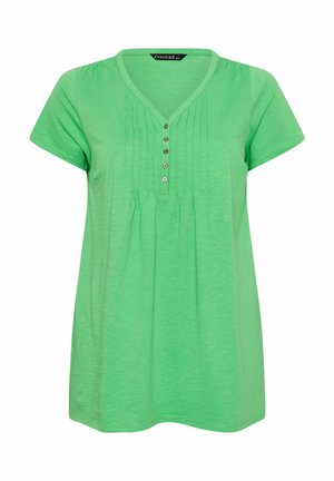 Blusa verde de manga corta con escote en V, cuatro botones en la parte delantera y pliegues verticales debajo del escote.