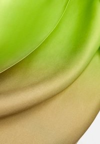 Tissu en satin aux dégradés de vert et d'or, présentant une texture lisse et une légère brillance, organisé en vagues superposées.